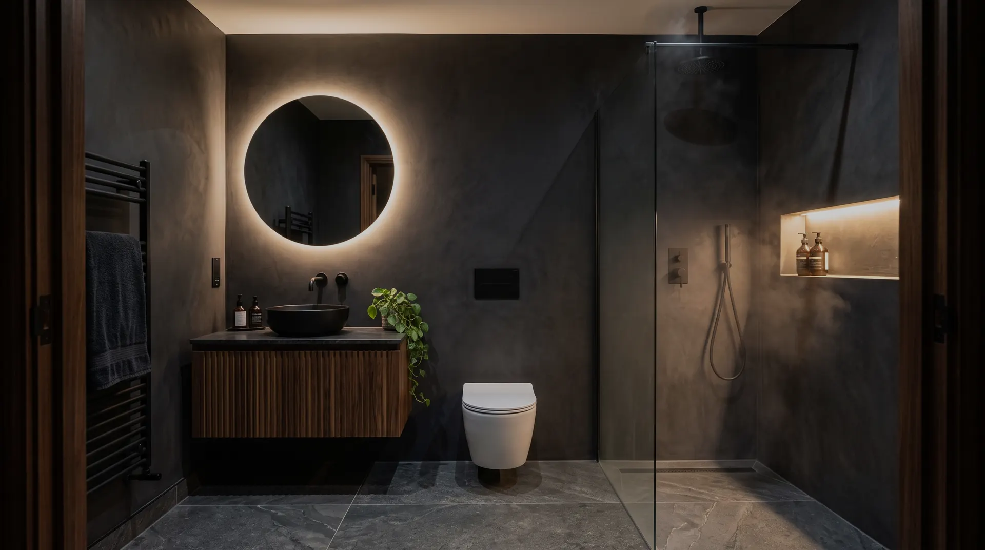 Dark modern bathroom with backlit round mirror, walnut vanity and walk-in shower